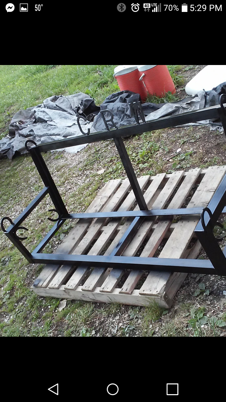 A metal frame is sitting on top of a wooden pallet.