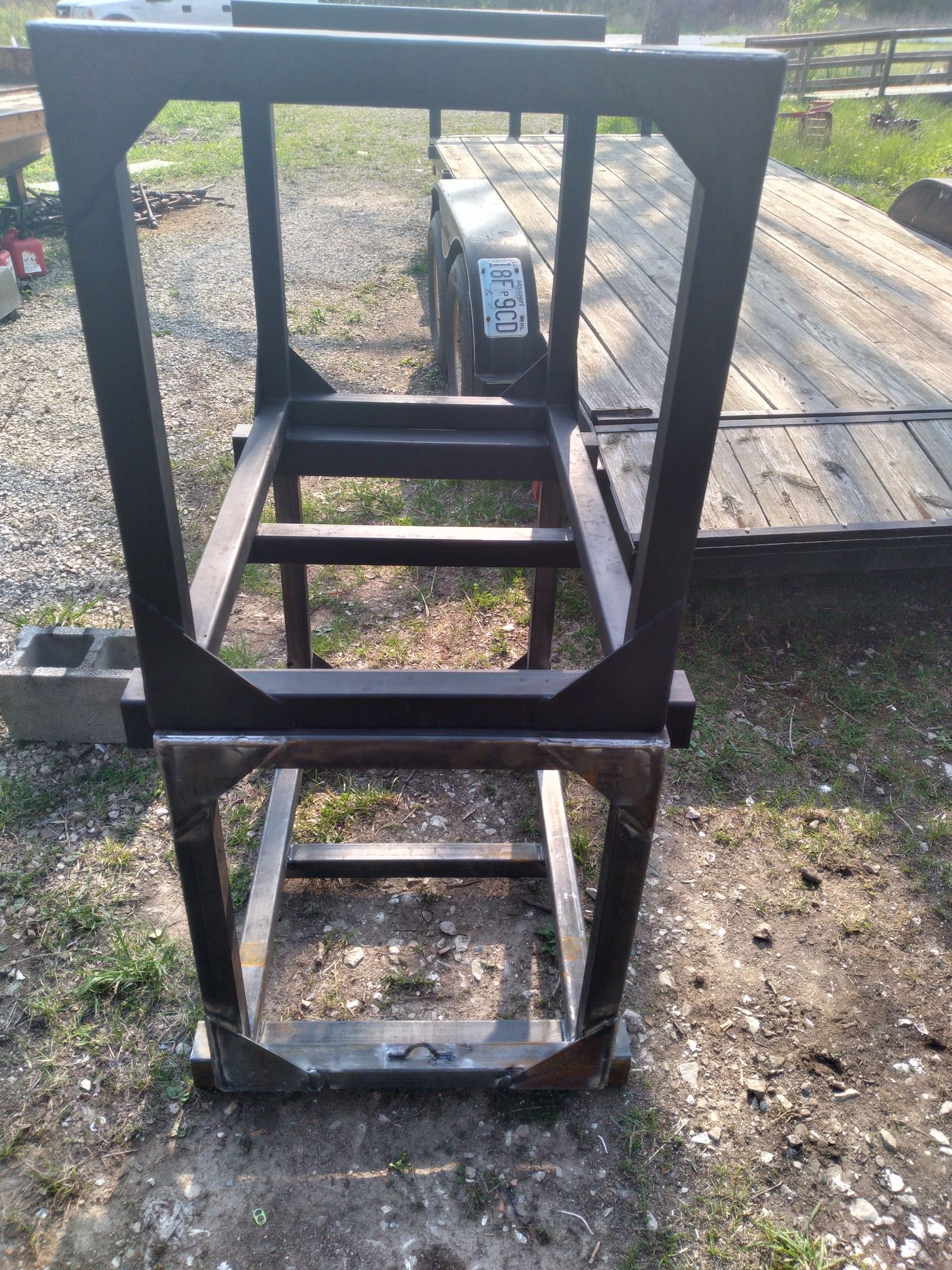 A black metal frame is sitting on top of a dirt field.