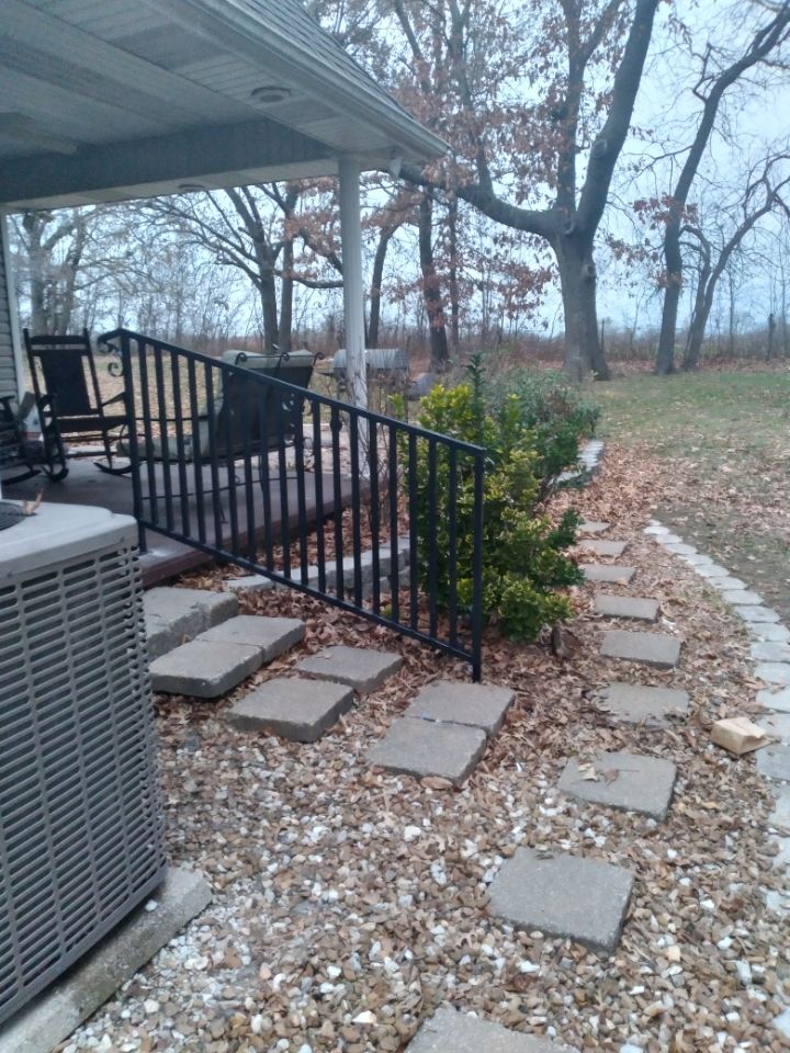 A patio with a fence and a walkway leading to it