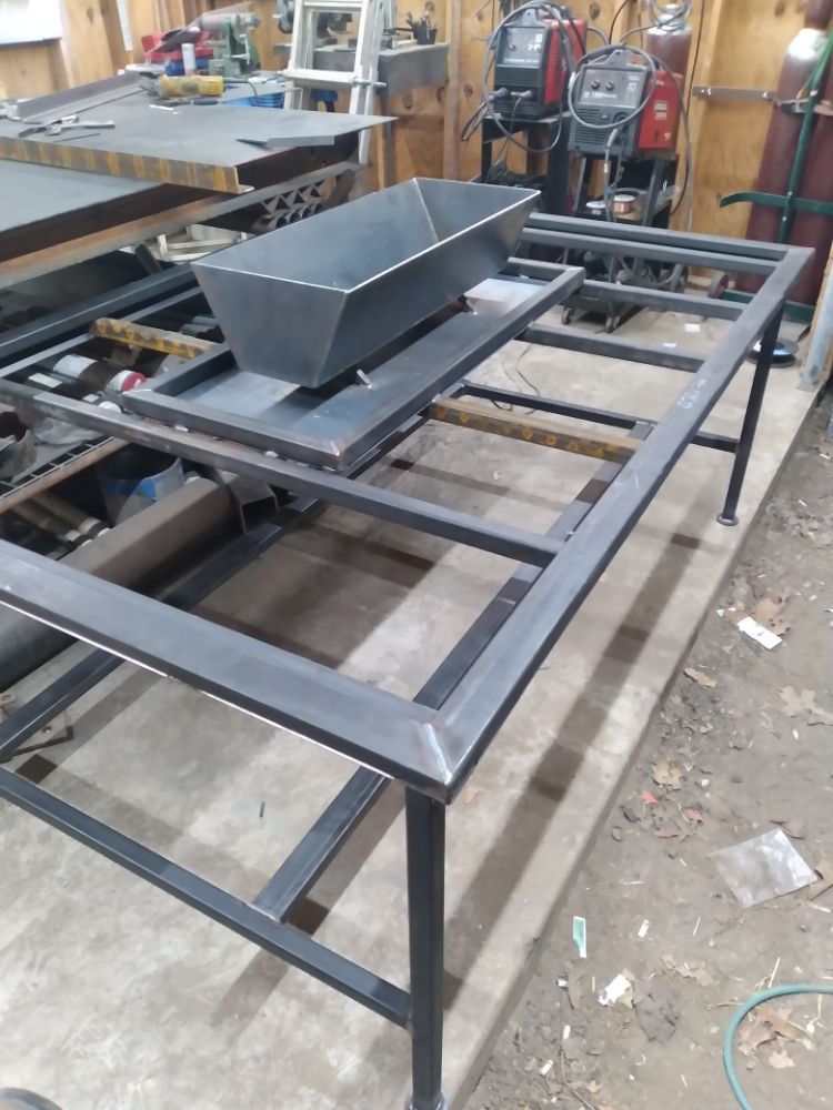 A metal table with a tray on top of it in a garage.