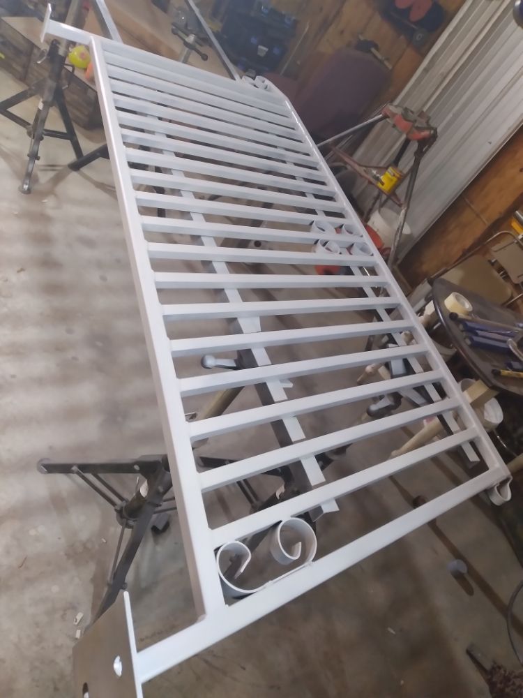 A white metal fence is sitting on top of a wooden table.