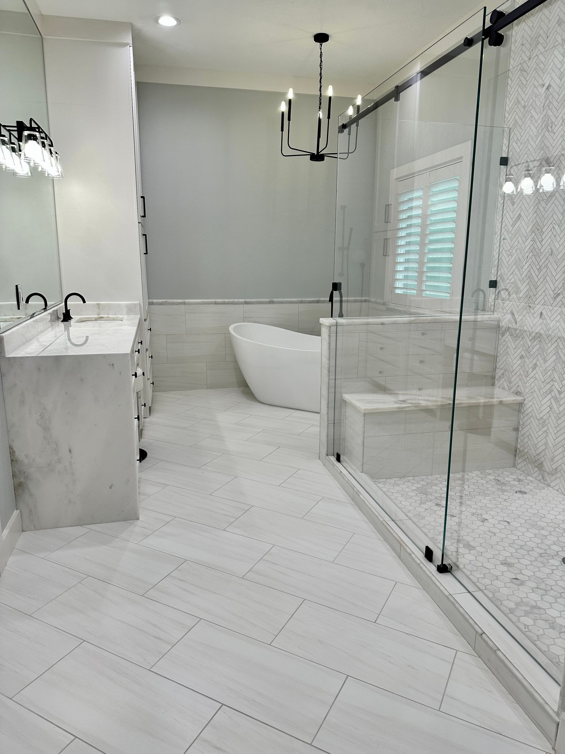 A bathroom with a bathtub , sinks , and a walk in shower.