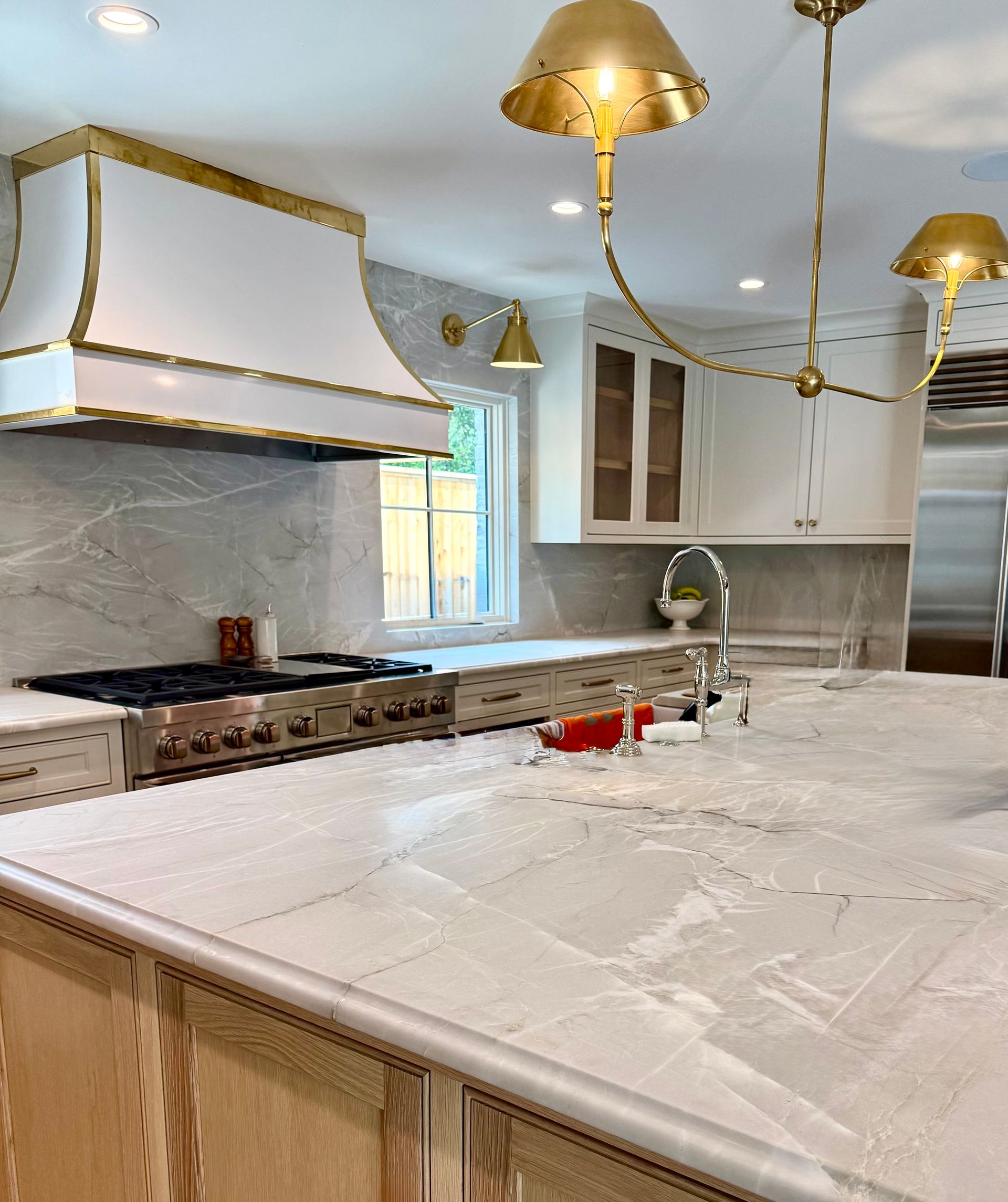 A kitchen with a stove top oven and a sink in kitchen island.