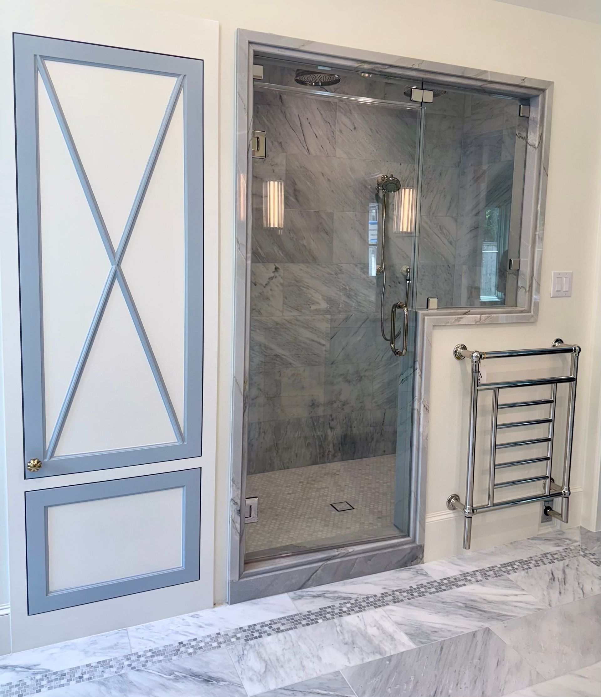 A bathroom with a walk in shower and a towel rack