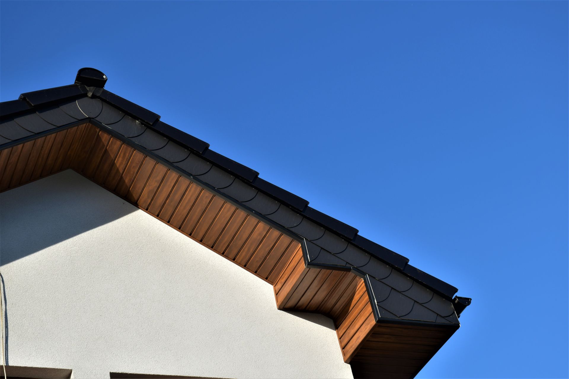 The roof of a house with a blue sky in the background