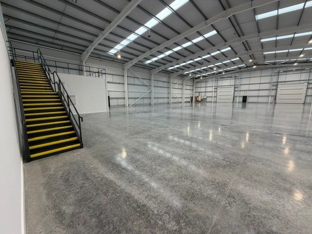 Clean warehouse interior with mezzanine level and factory flooring