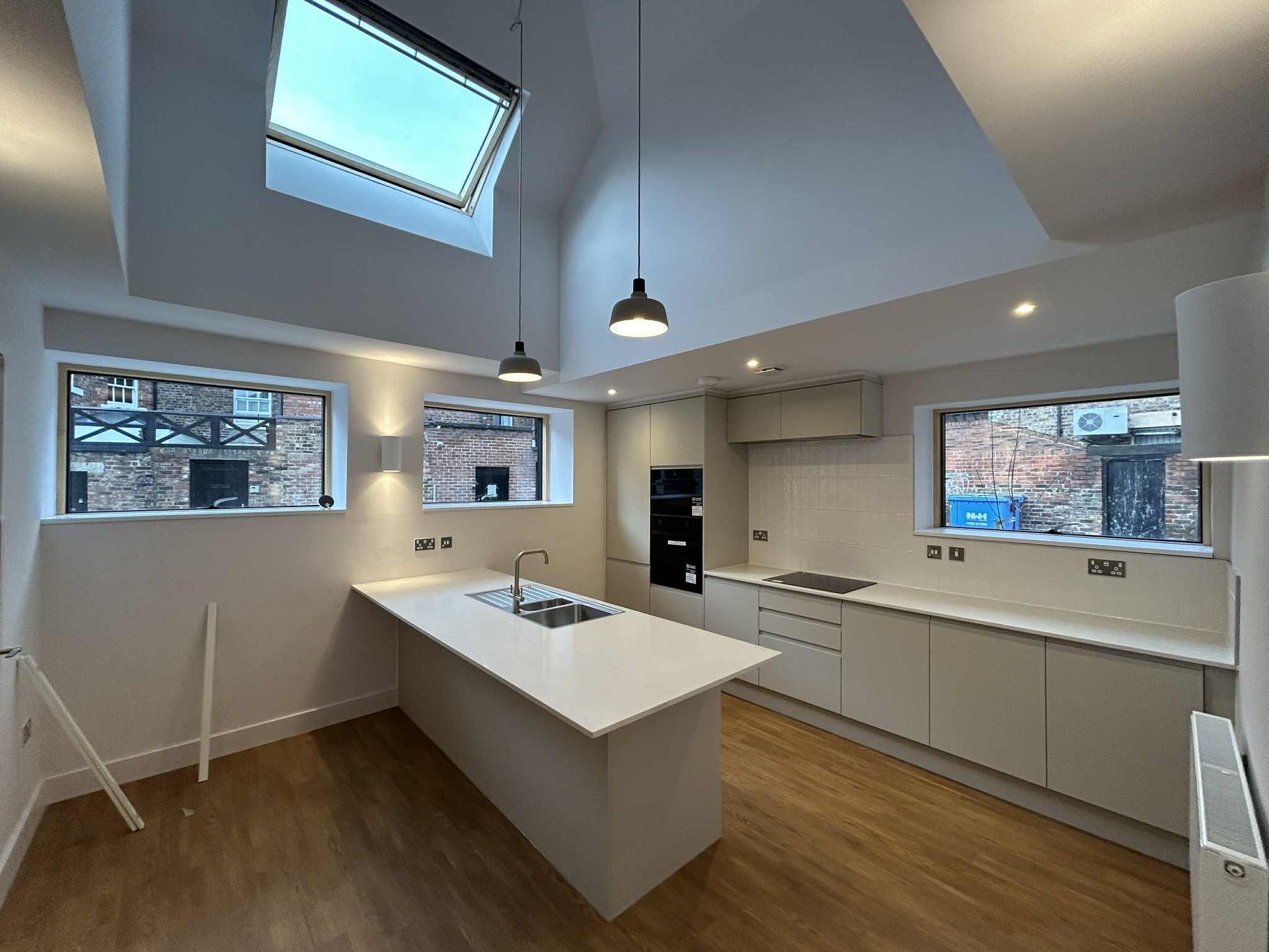 Modern apartment kitchen with white cabinets and island after builders clean