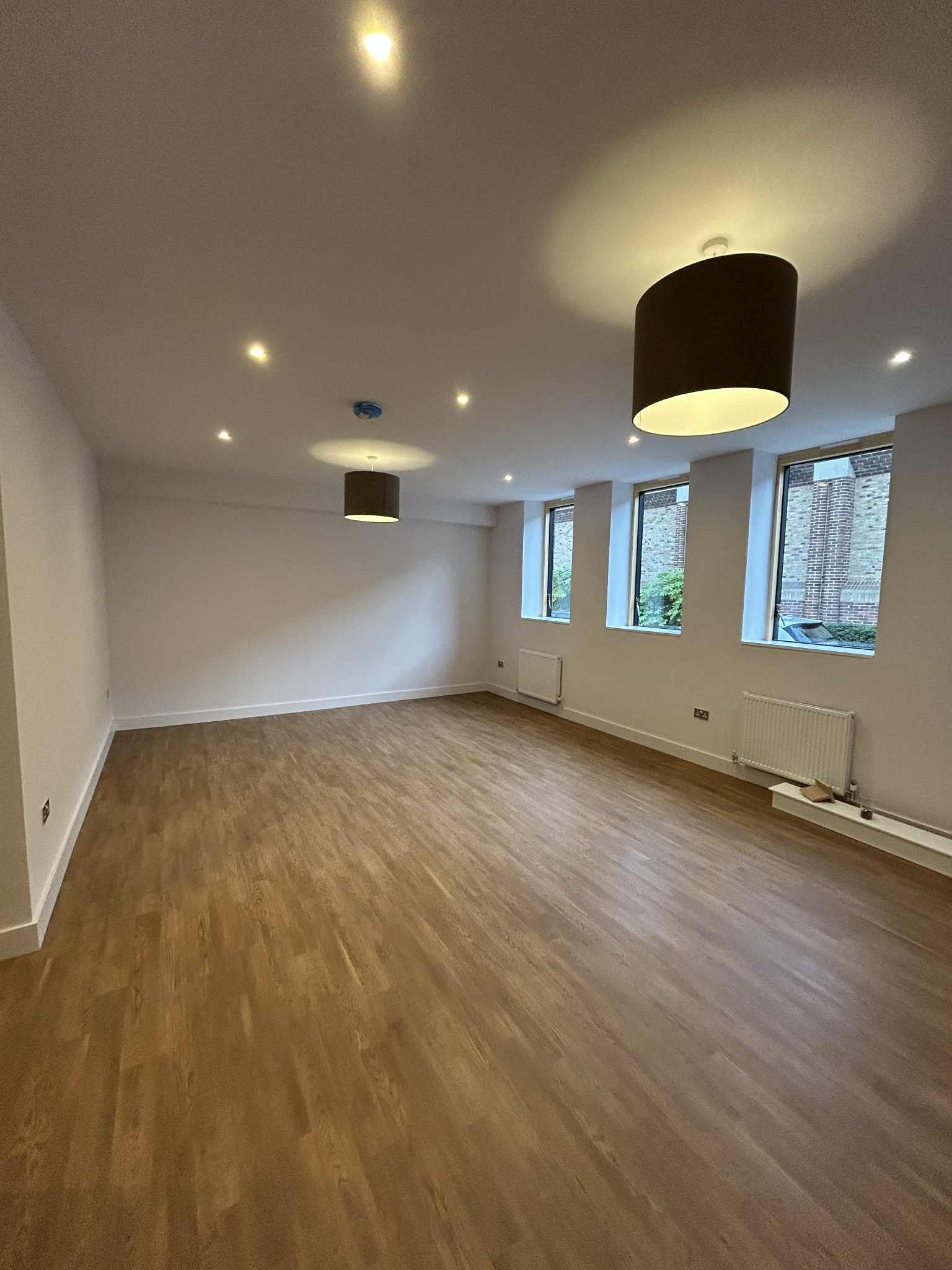 Clean open-plan apartment living area with modern lighting 