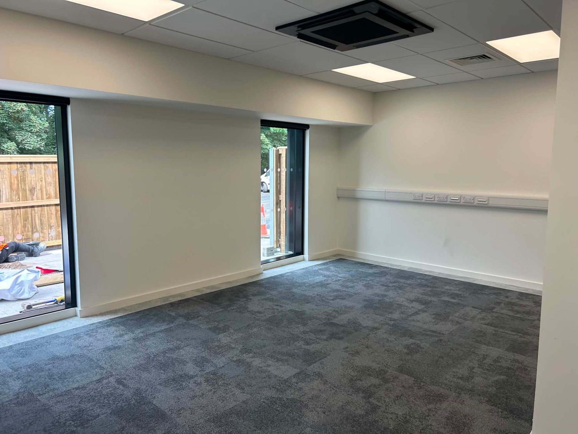 Training room with air conditioning unit and clean flooring after final clean