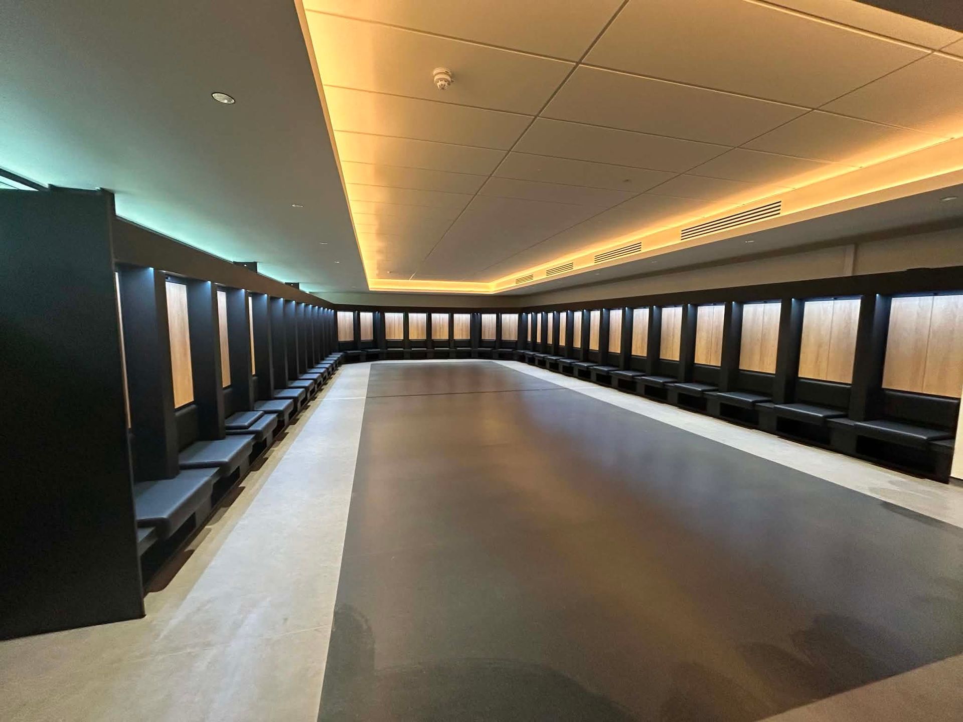 Long corridor with player lockers and bench seating after final clean
