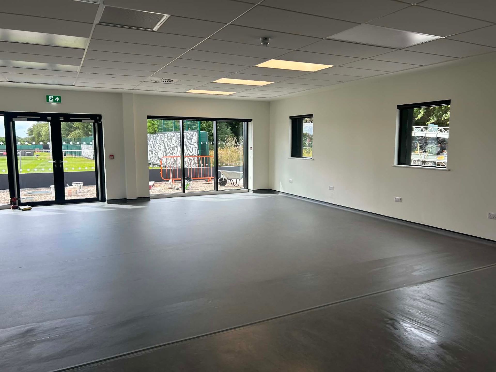Clean open room with flooring and entrance doors at Newcastle United Training Ground 