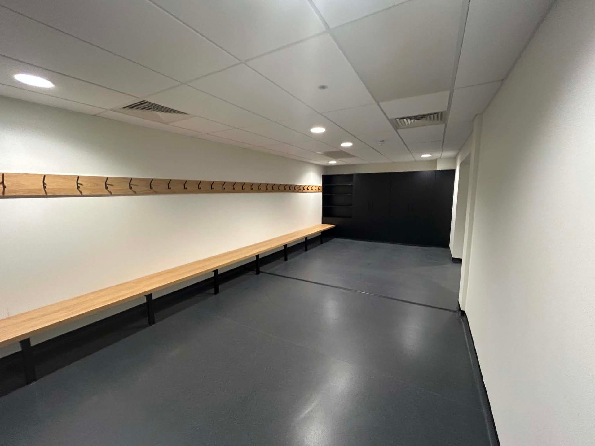 Clean corridor with built-in seating and dark flooring 