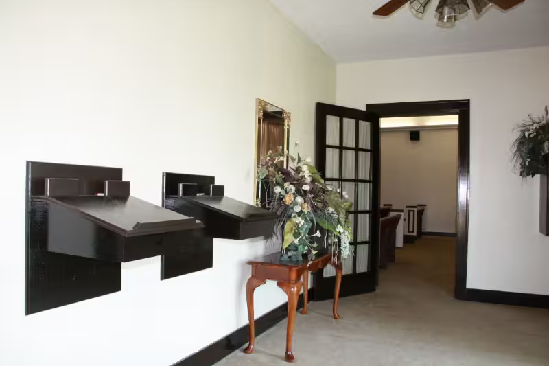 Lobby with wall-mounted mail slots, a small table with flowers, and open double doors leading to another room