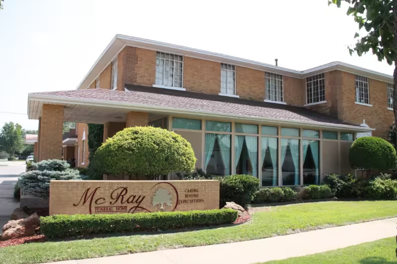 Brick building with manicured lawn and “McRay” sign at the entrance