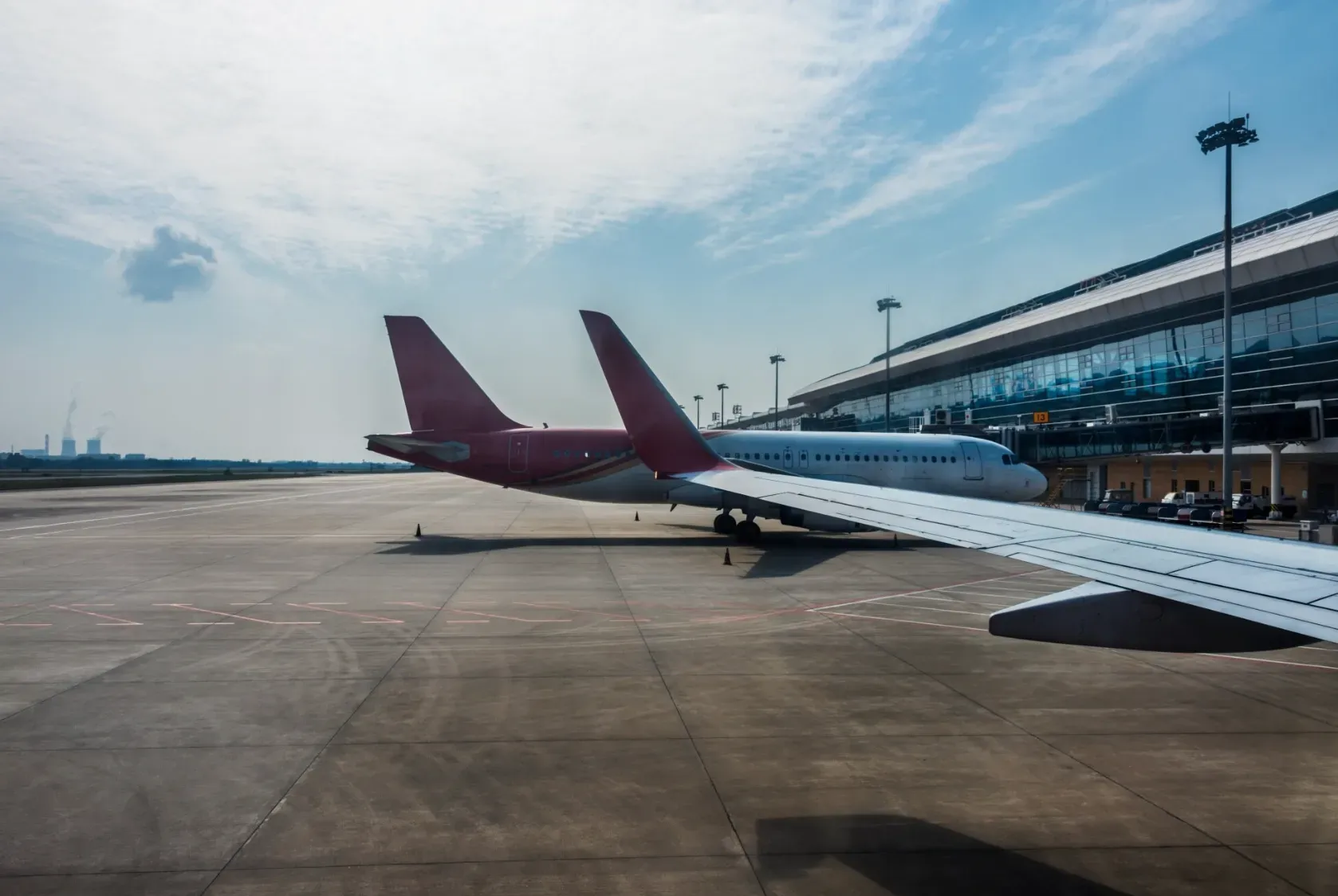 aerporto Aviões comerciais estacionados na pista de um aeroporto moderno, ilustrando as opções de voo para chegar a Gramado.