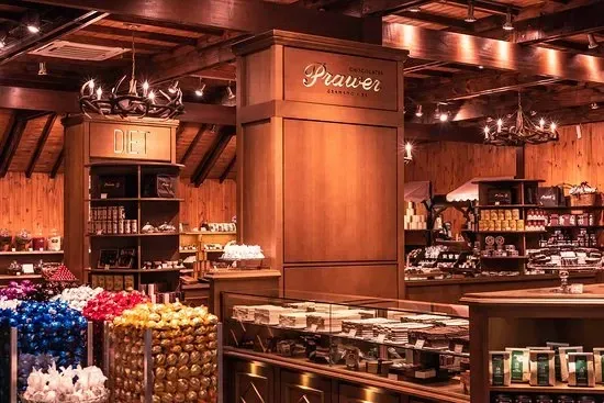Interior com acabamento em madeira rústica da loja de Chocolates Prawer em Gramado, exibindo embalagens e bombons artesanais.