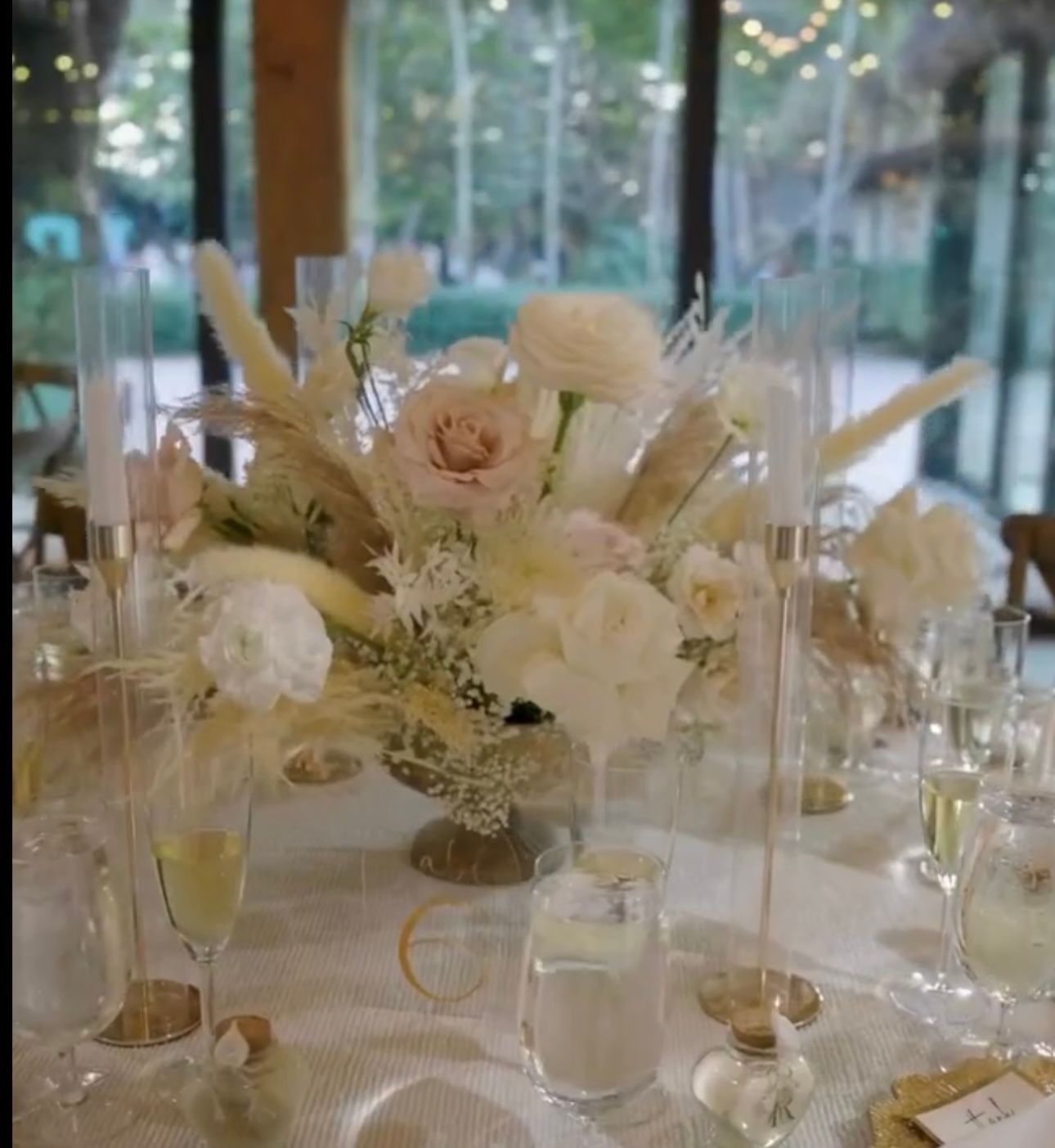 Floral centerpiece on a decorated table with champagne glasses.