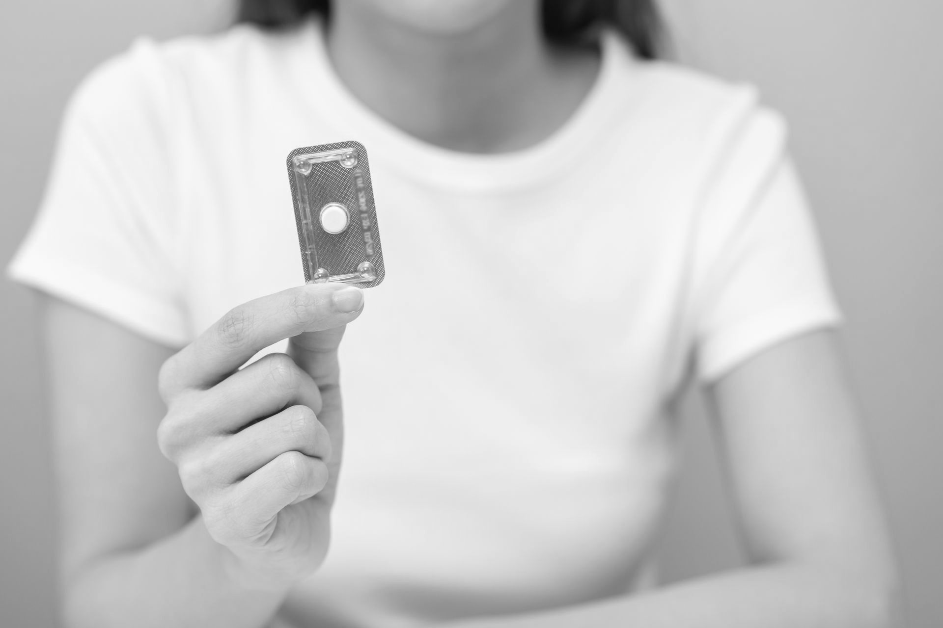A woman holding an abortion pill.