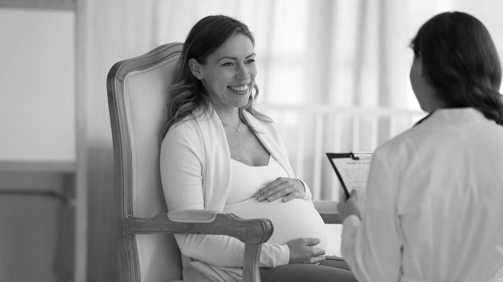 pregnant woman talking to healthcare provider about STD/STI testing