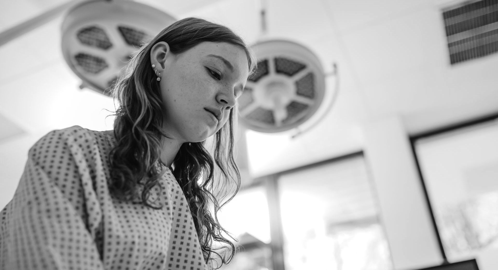 A worried young woman staring at a pregnancy test.