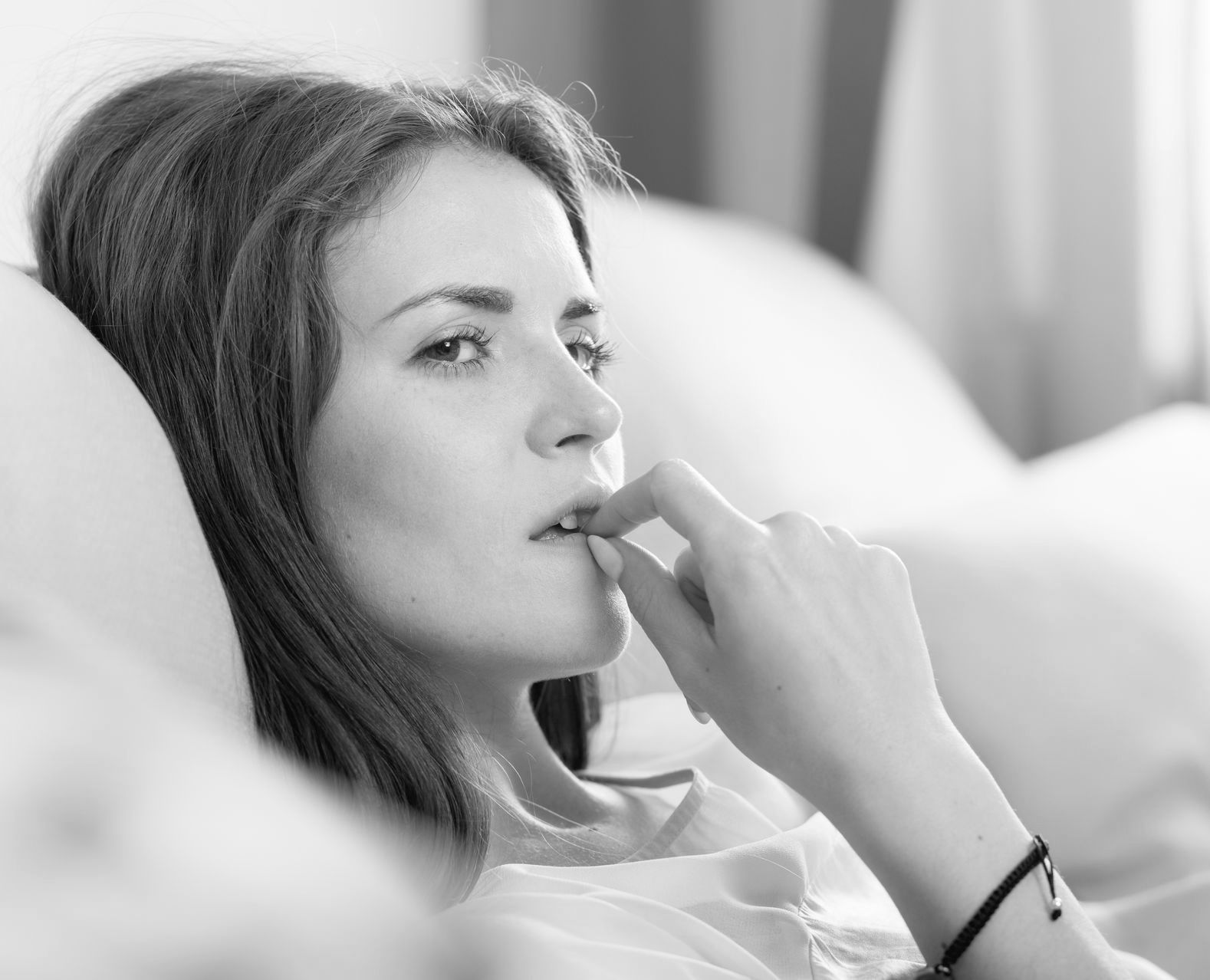 A woman biting her nails.