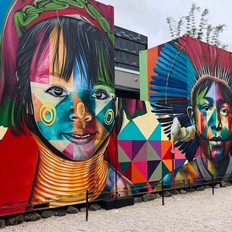 A colorful mural of a woman and a man on the side of a building