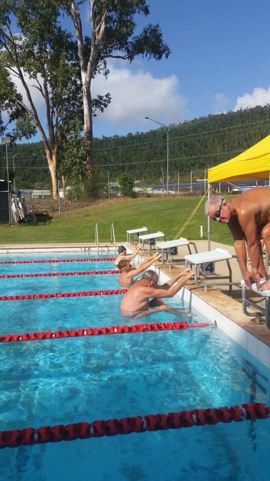Several Swimmers Prepare to Start a Race at an Outdoor Pool — Cannonvale Swim Centre In Cannonvale, QLD