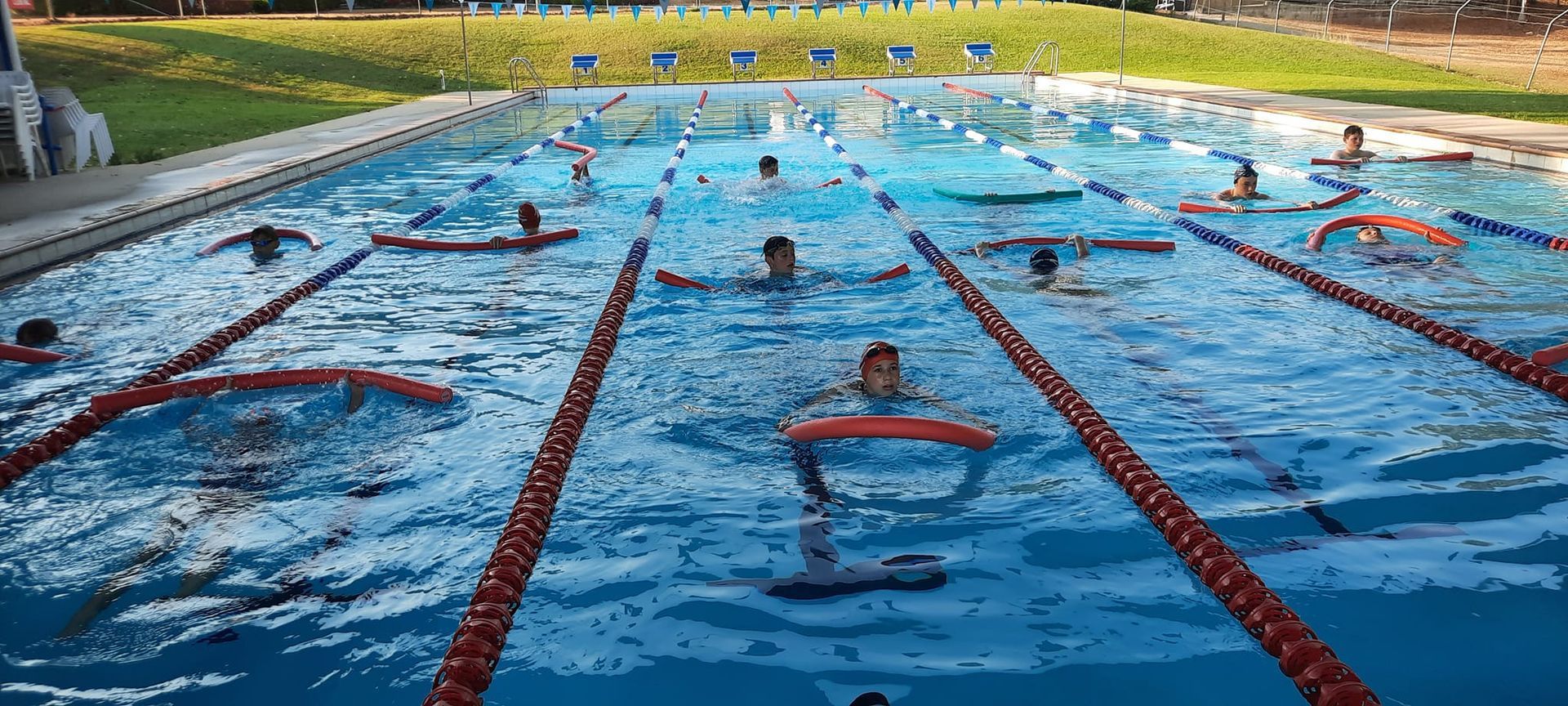 Swimmers in a Pool Race, Water Splashing. Red Lane Markers — Cannonvale Swim Centre In Cannonvale, QLD