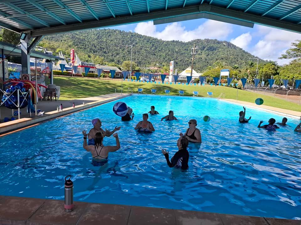People In A Pool, Exercising Under A Blue Roof With A Mountain Backdrop — Cannonvale Swim Centre In Cannonvale, QLD