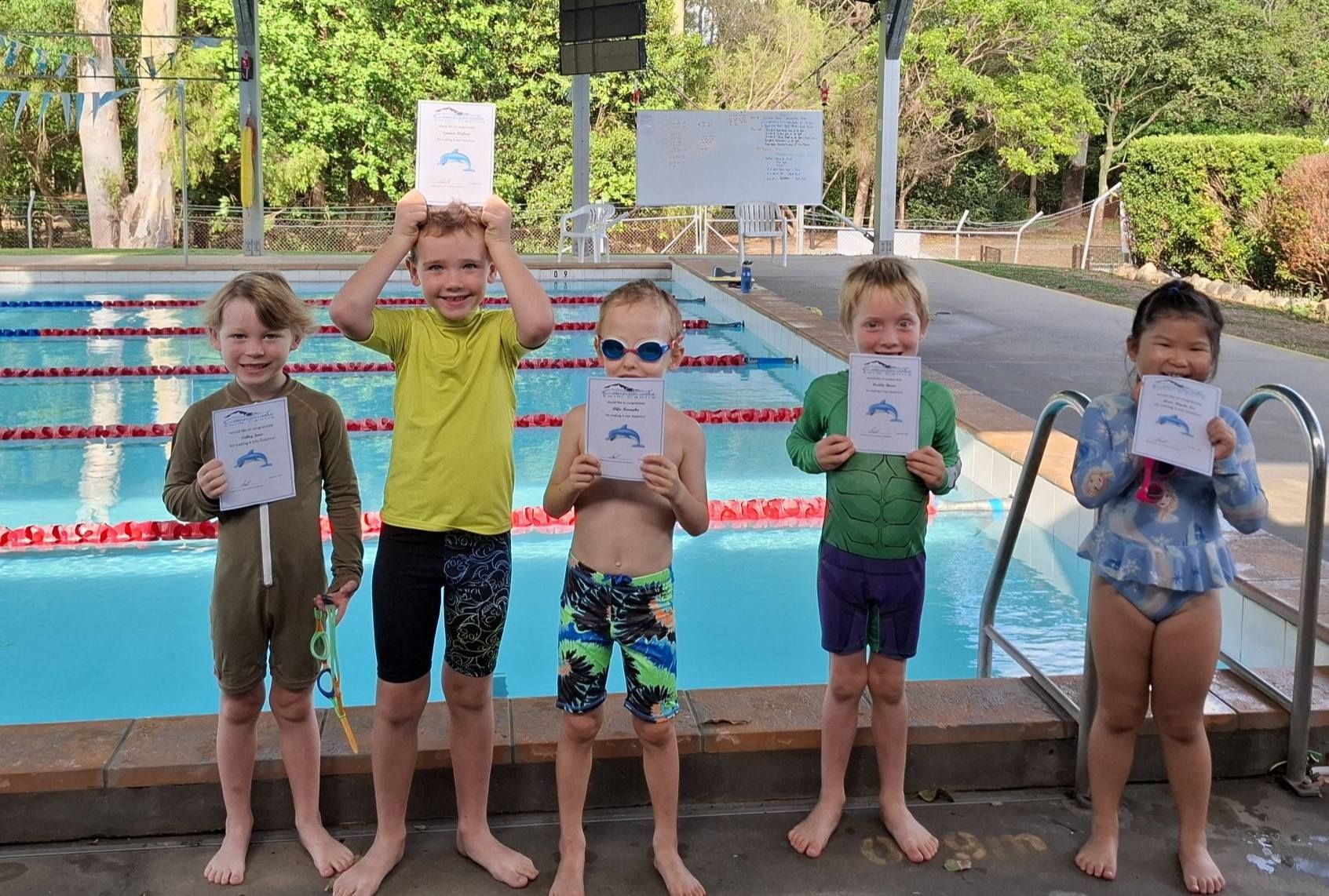 Five Children Holding Certificates Stand by a Pool — Cannonvale Swim Centre In Cannonvale, QLD