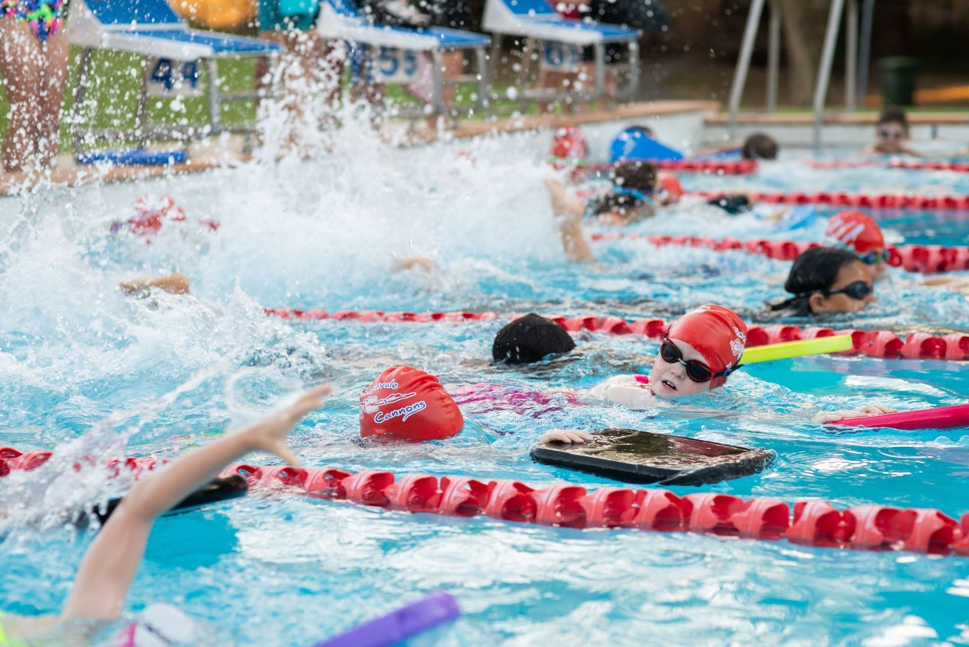 Swimmers in a Pool Race, Water Splashing. Red Lane Markers — Cannonvale Swim Centre In Cannonvale, QLD