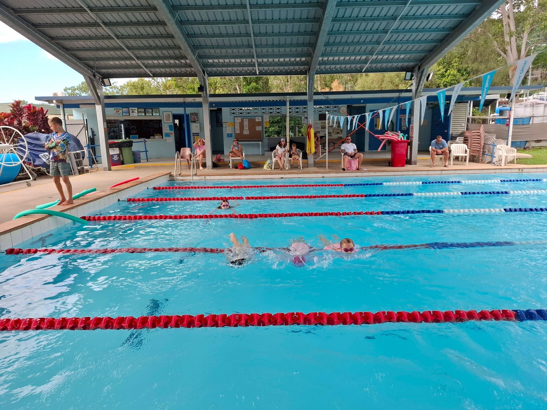 Swimmers Racing in an Outdoor Pool With Red Lane Dividers — Cannonvale Swim Centre In Cannonvale, QLD