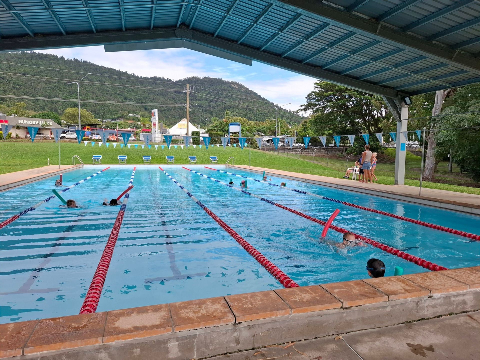 Outdoor Lap Pool With Swimmers, Red Lane Ropes — Cannonvale Swim Centre In Cannonvale, QLD