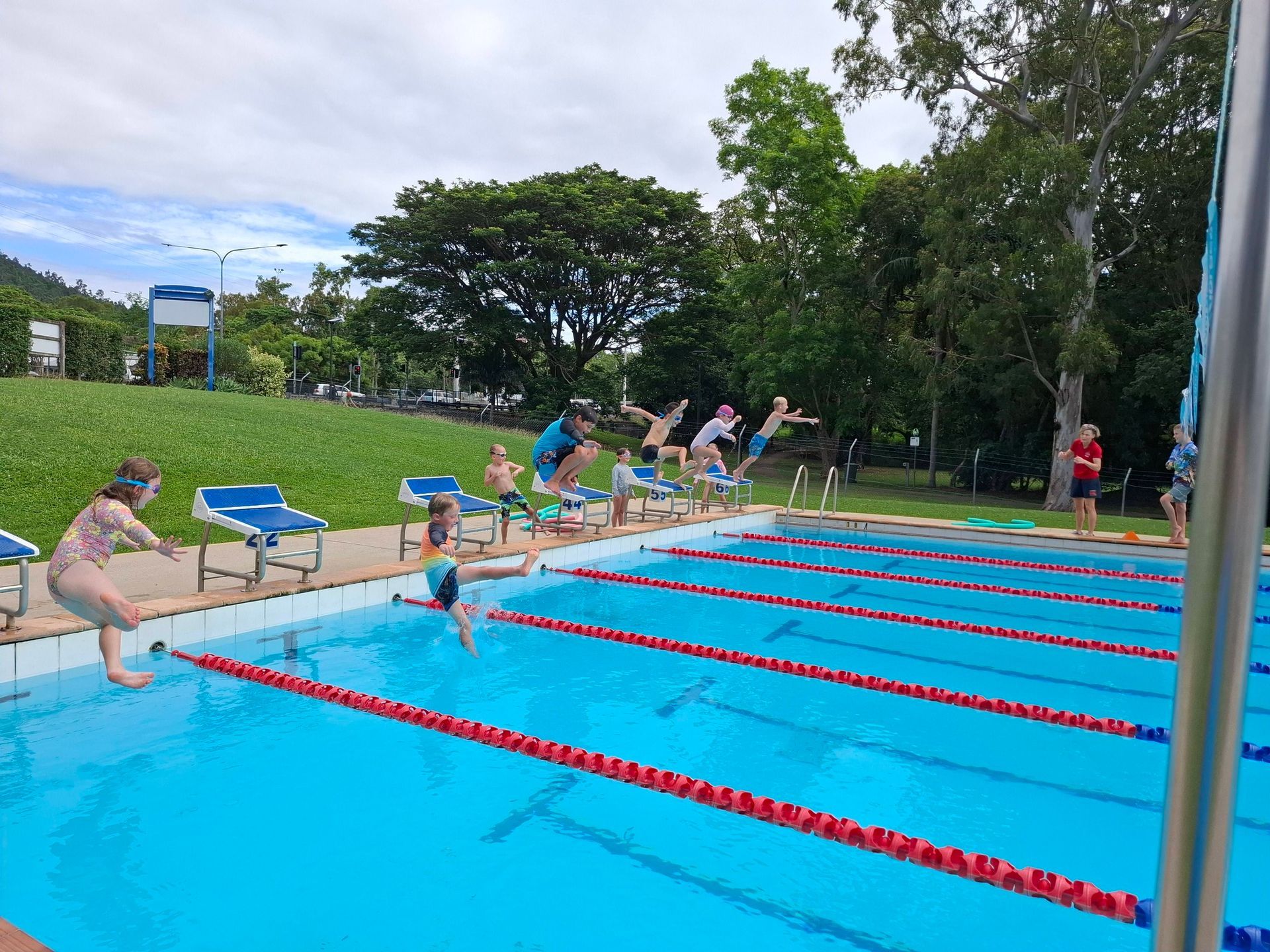 Swimmers Racing in an Outdoor Pool With Red Lane Lines — Cannonvale Swim Centre In Cannonvale, QLD