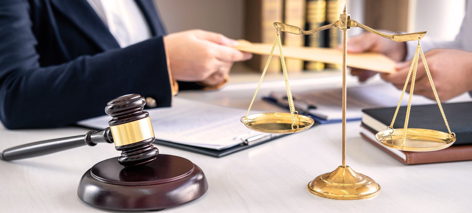 A judge is sitting at a desk with a gavel and scales of justice.