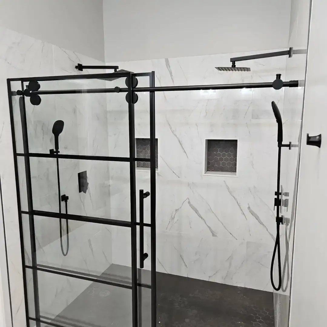 A bathroom with a sliding glass shower door and a shower head.