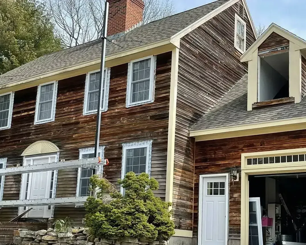 A large wooden house with a ladder in front of it.