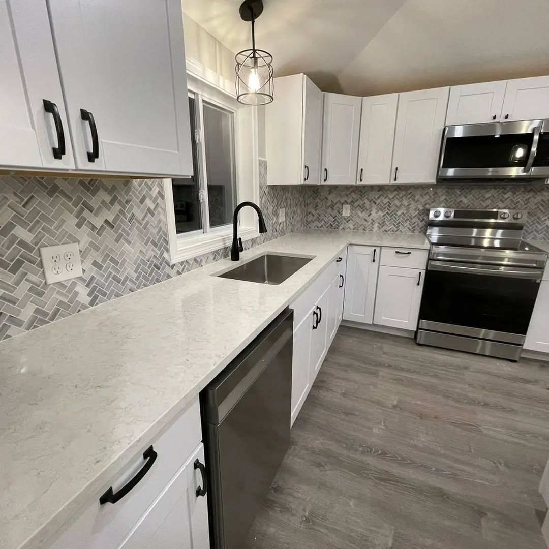 A kitchen with white cabinets and stainless steel appliances