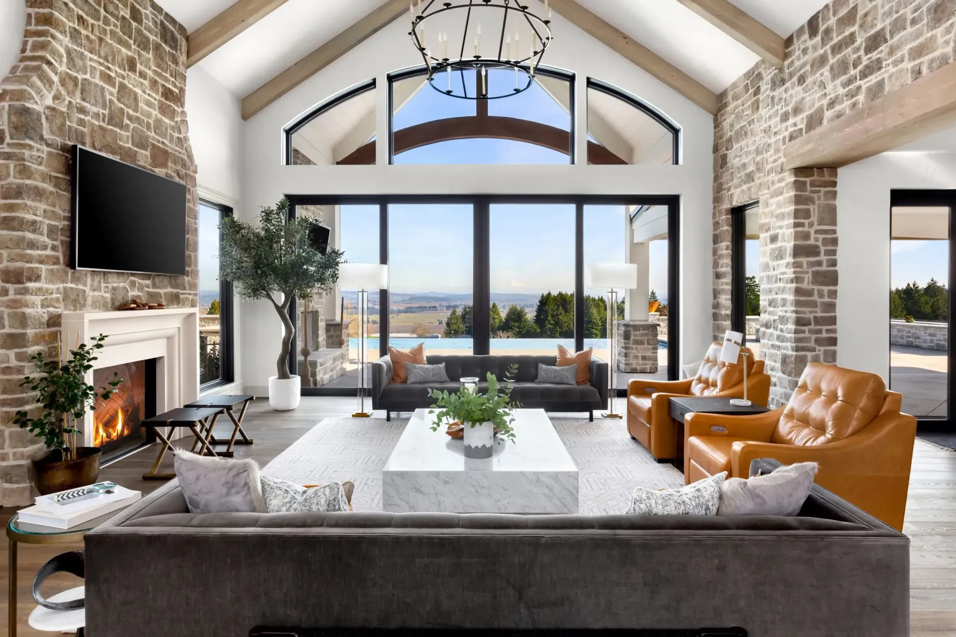 A living room with a couch , chairs , fireplace and television.