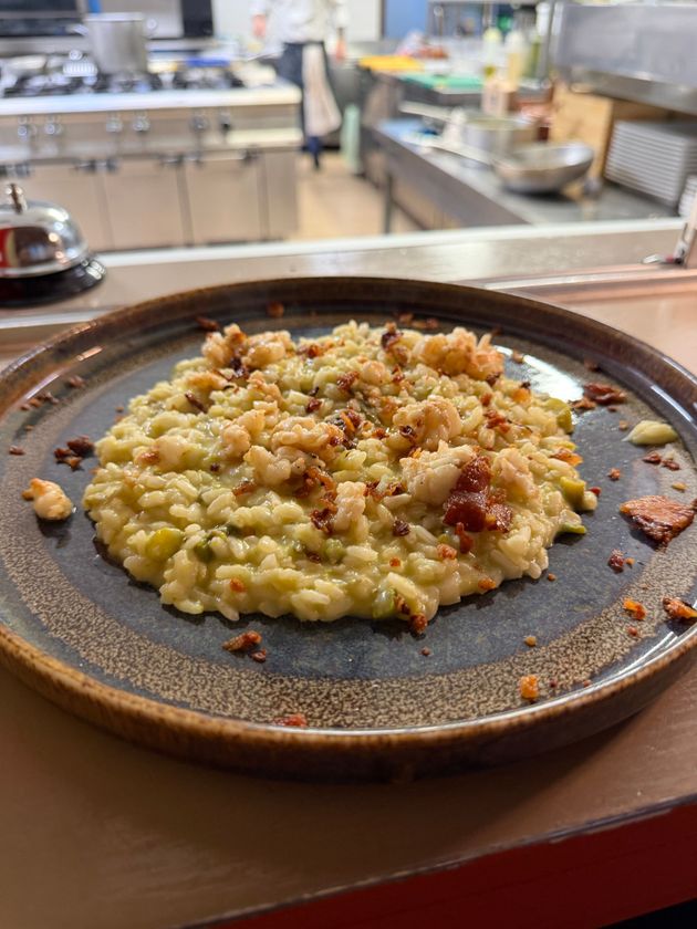 Tartare di tonno crudo su un piatto bianco, guarnita con fette d'arancia e verde.