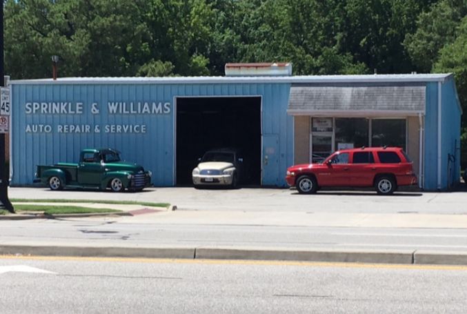 Sprinkle & Williams Auto Repair shop with a green truck, white car, and red SUV parked in front. | Sprinkle and Williams II, Inc.