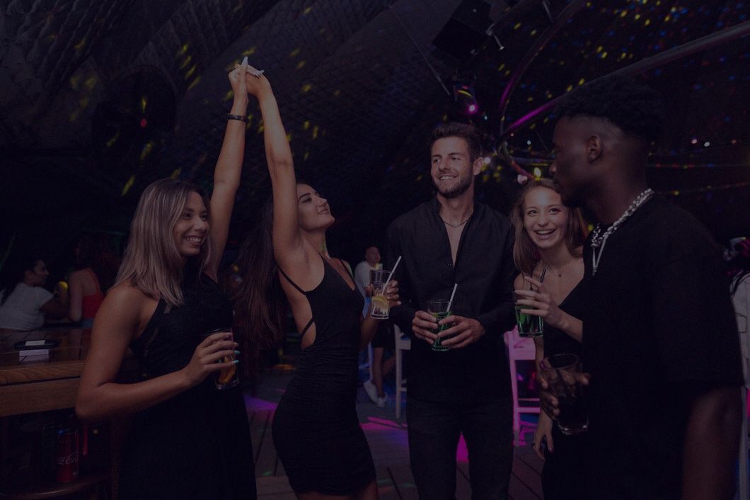 A group of people are dancing at a party in a club.