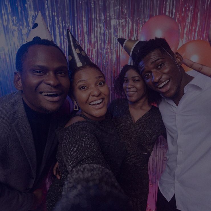 A group of people wearing party hats are posing for a picture.