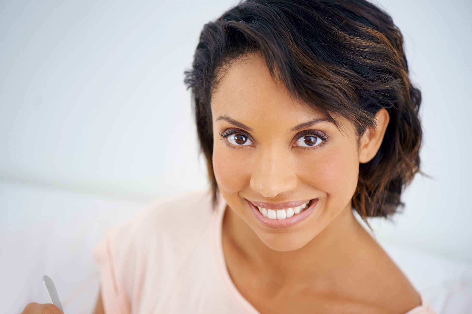 Woman with short, dark hair, smiling, looking directly at the camera.