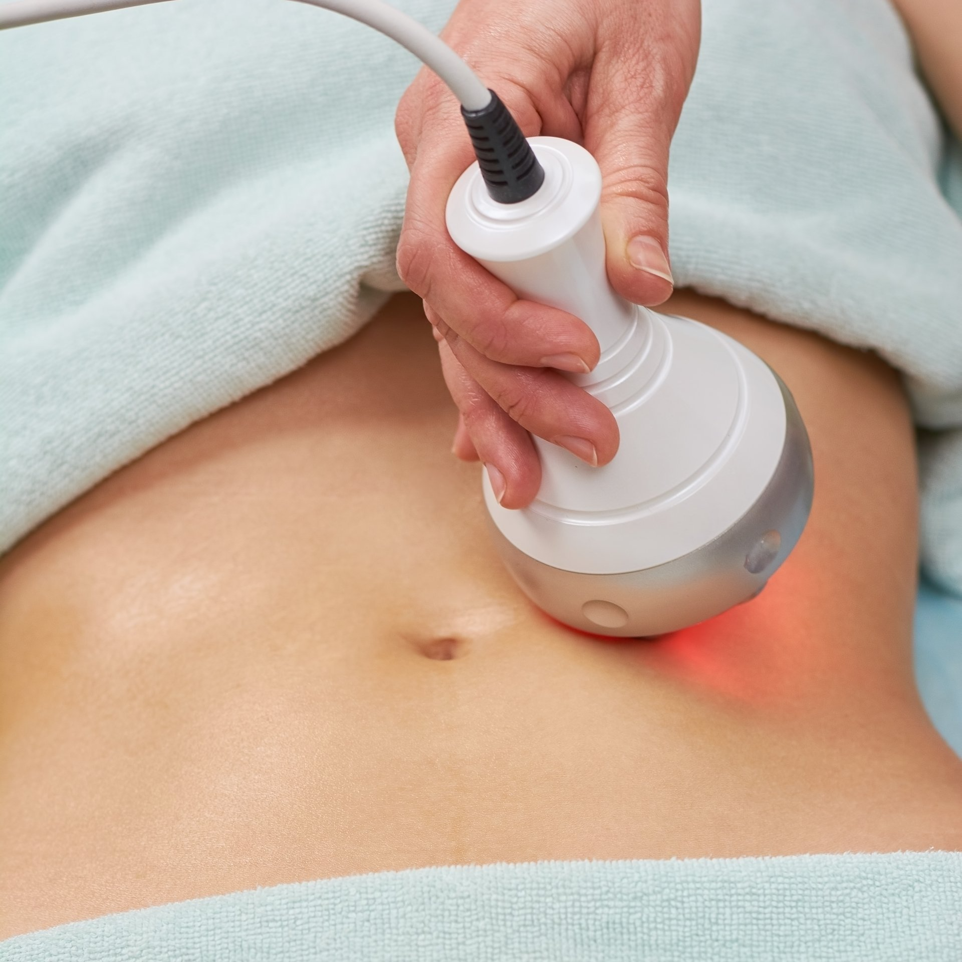 Provider performing a non-surgical body-contouring treatment on a patient’s abdomen