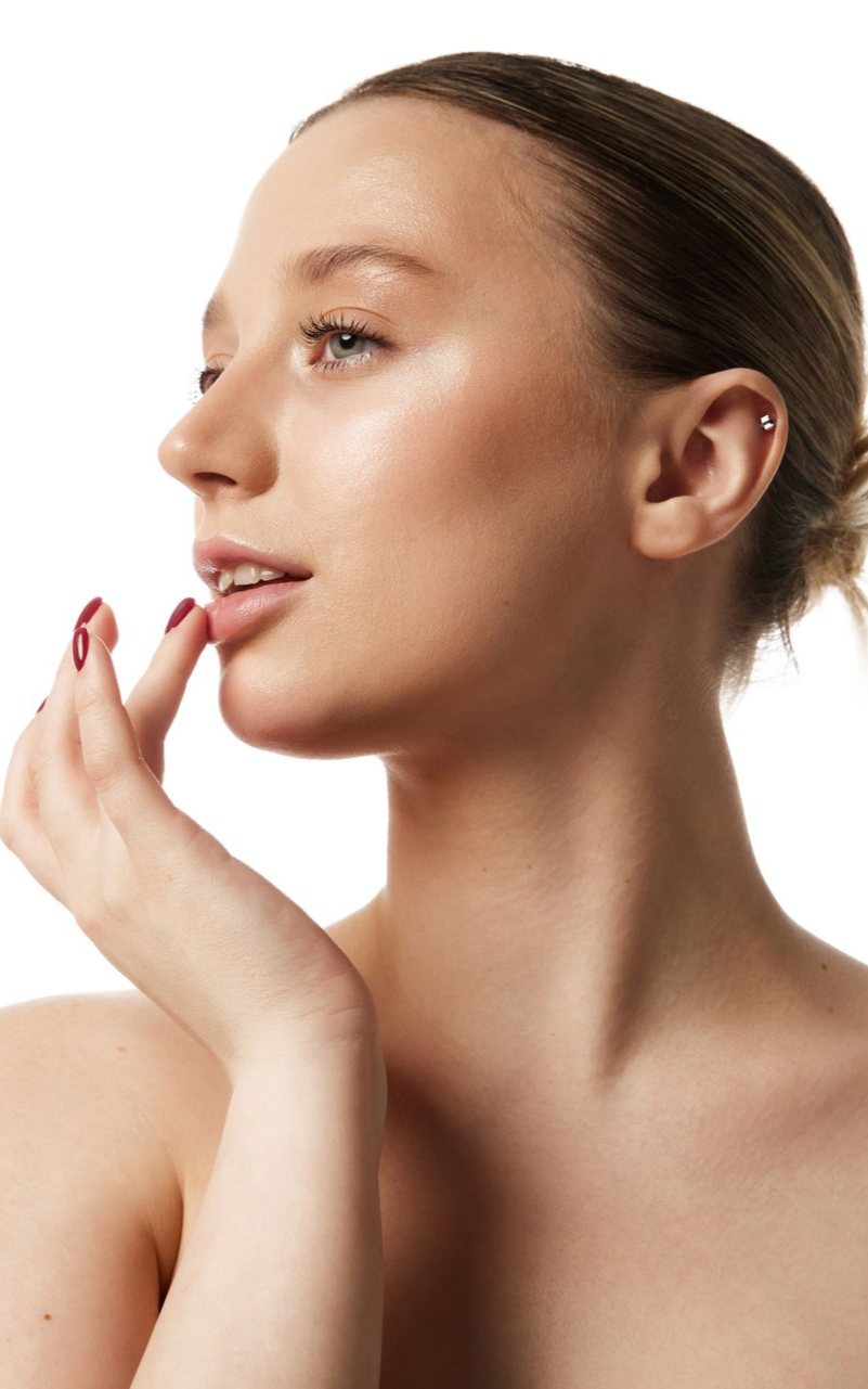 Woman touching her lips, side view, pale skin, light makeup, ear piercing.