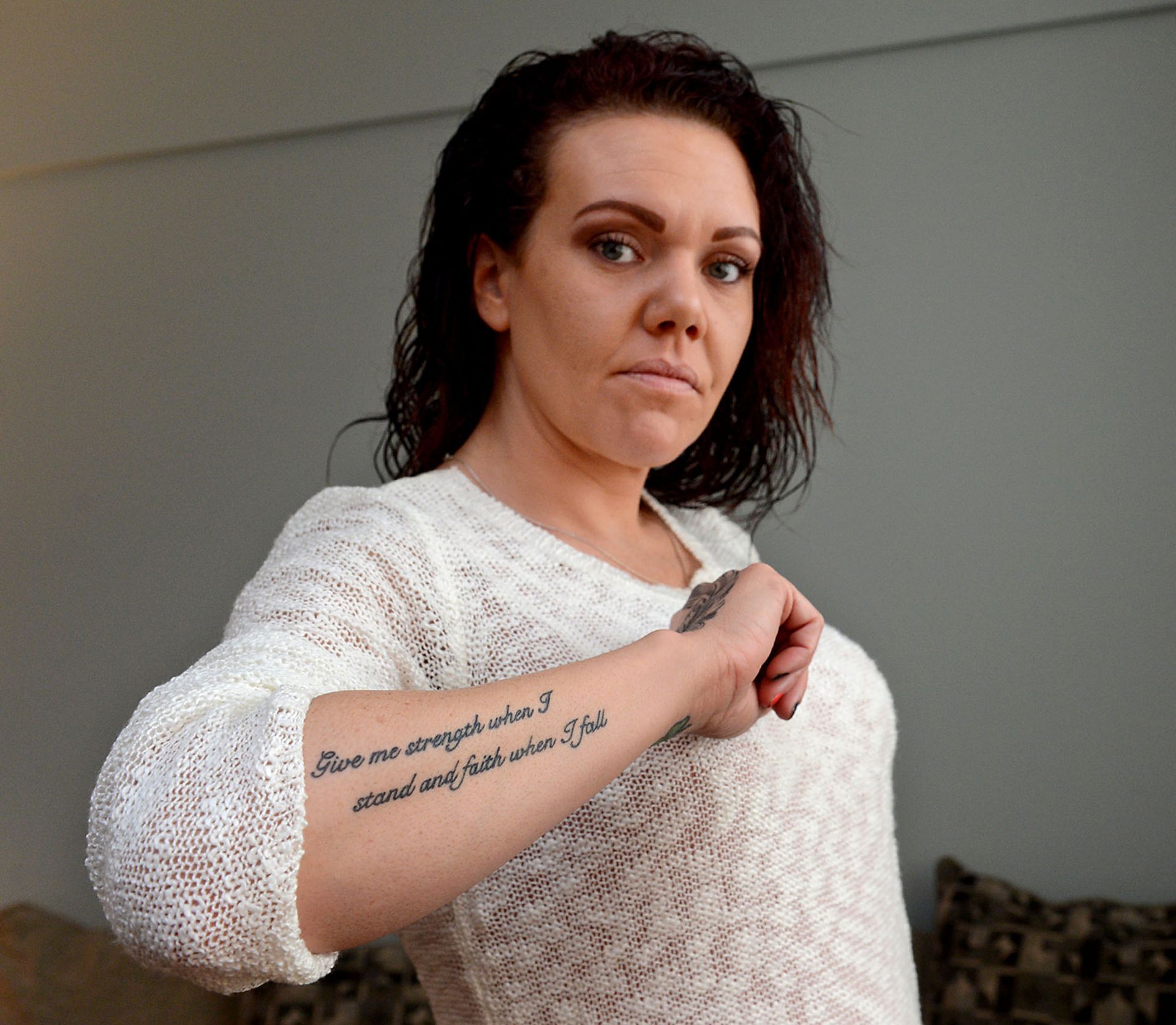 Keriann Kilcoyne, a recovering addict who now works at a detox center in Boston, displays a tattoo on her arm which reads