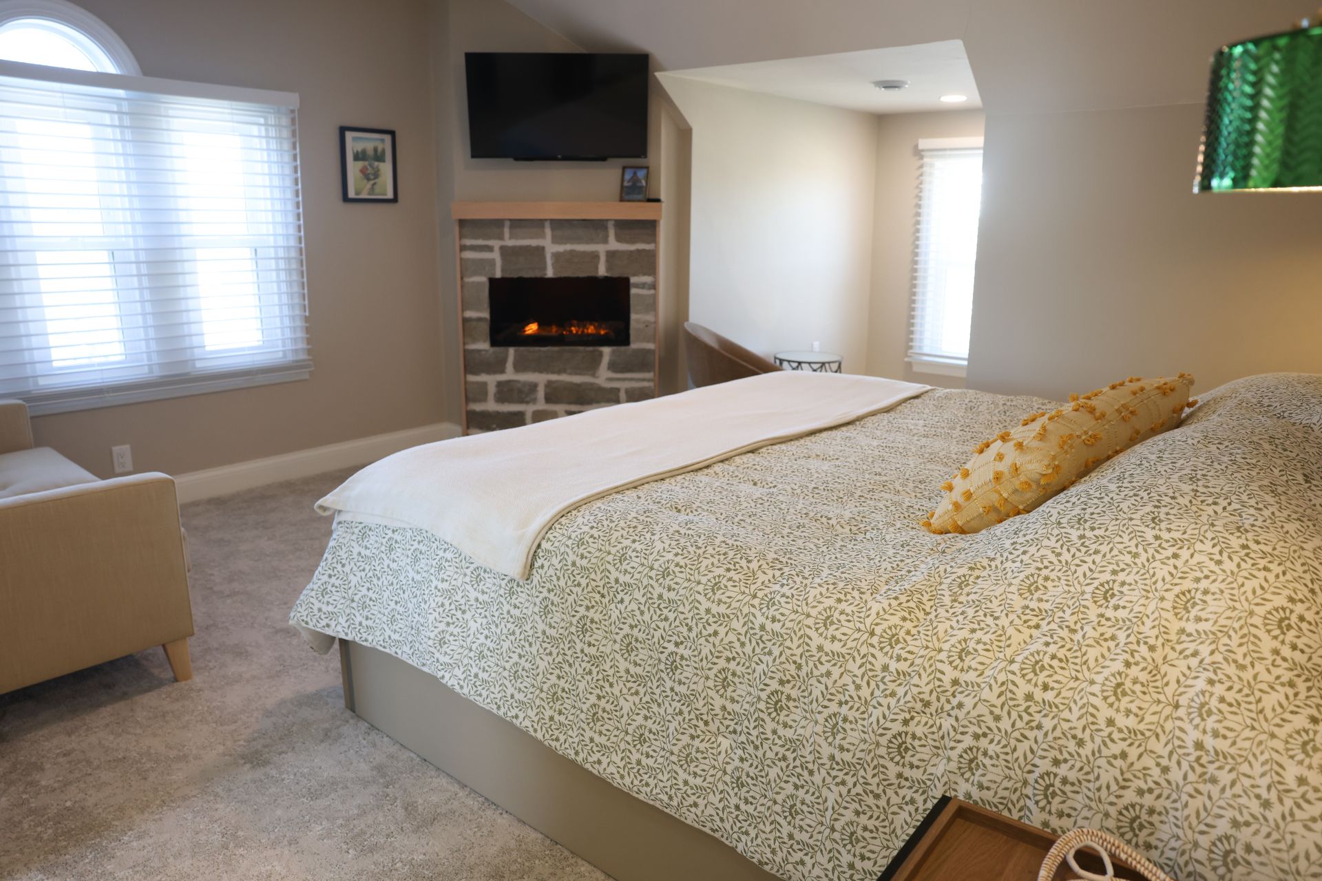 There is a bed in the middle of the room with a wooden headboard.