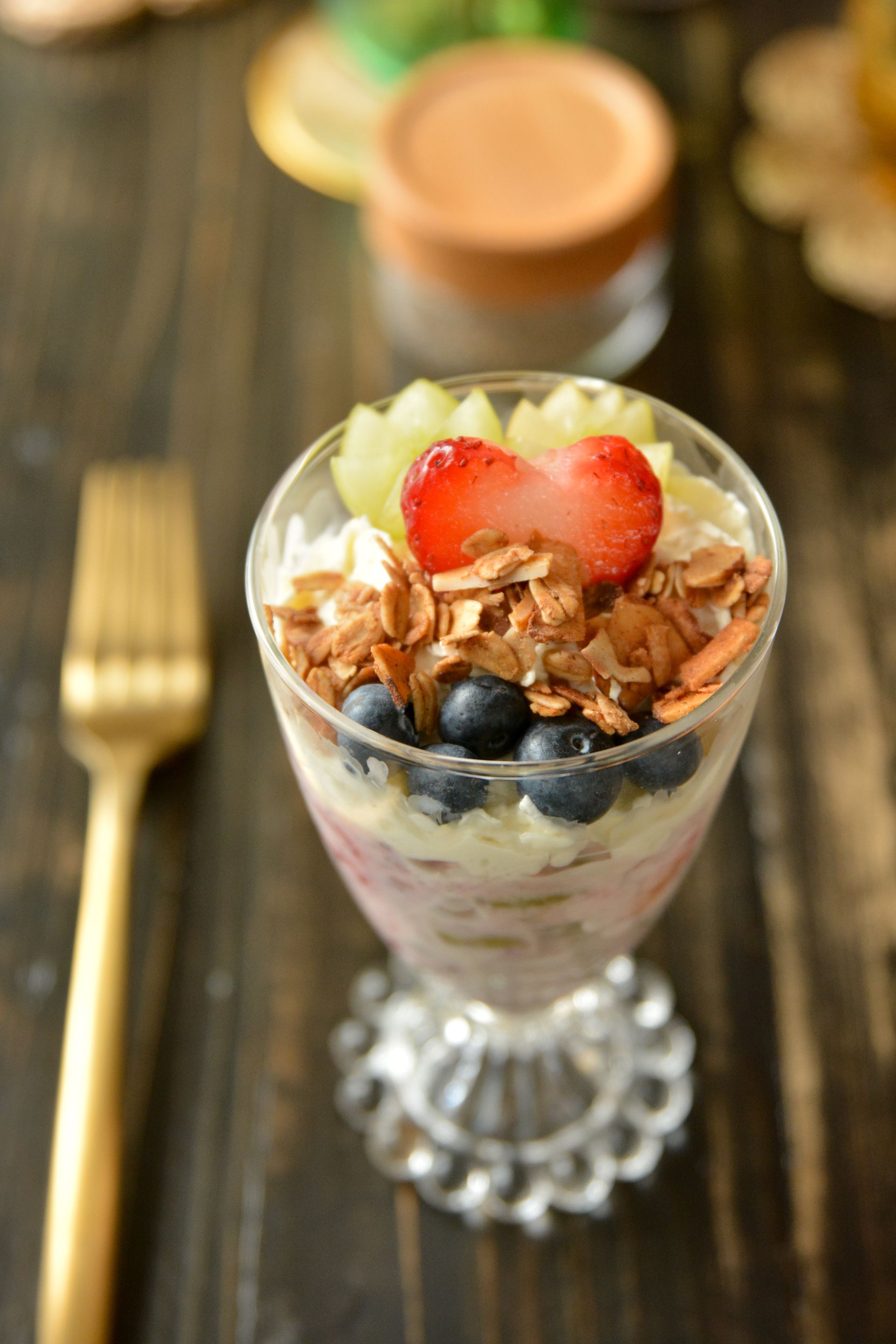 Fruit salad in a cup with a heart shaped strawberry on top