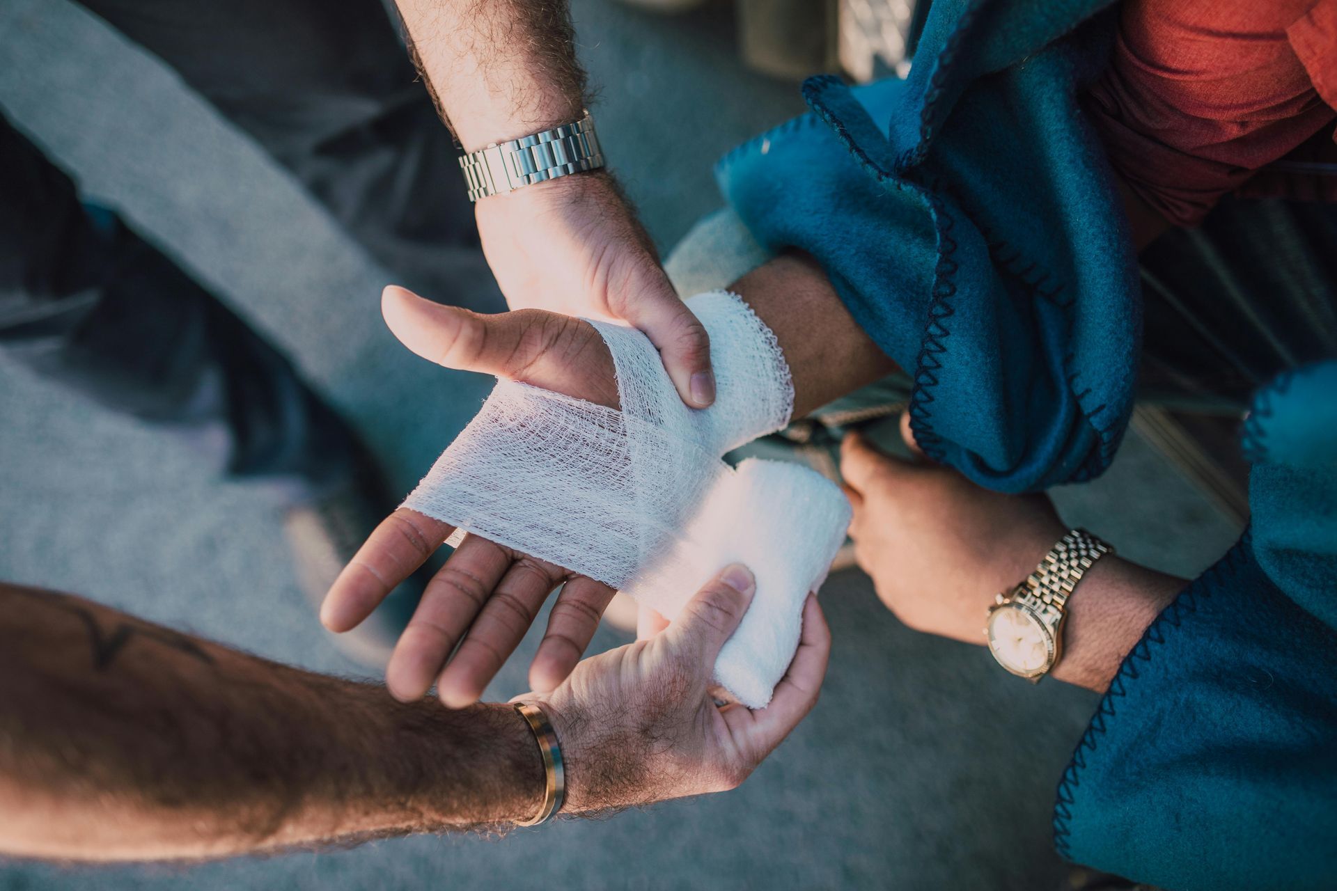 Hands wrapping a wrist injury with white medical bandage.